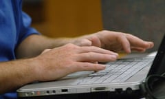 Man's hands typing on laptop.