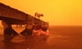 A family take refuge under a jetty during widfire on Australia