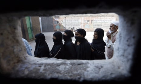 Voters line up to vote in the State assembly elections at a polling station in the Zafrabad area of east Delhi, India. 