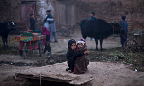 A Pakistani girl holds her brother wrapped with a blanket in the evening cold in Islamabad.