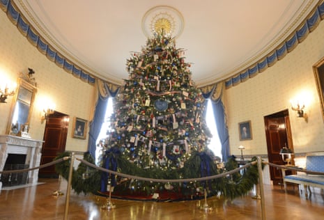 Decorations honouring military families hang upon the official White House Christmas tree in the Blue Room at the White House in Washington, DC.