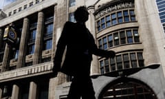 A pedestrian passes offices of Goldman Sachs in London