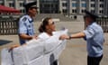 Police take away a protester outside the court in Jinan where Bo Xilai is to stand trial