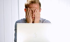 Man with head in hands at laptop
