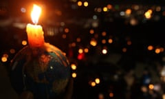 People hold candles during Earth Hour after lights were turned off in central Amman