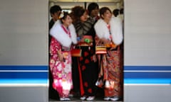 Women in kimonos ride a train after a ceremony celebrating Coming of Age Day at an amusement park in Tokyo, Japan.
