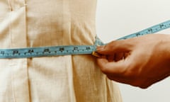 Measuring woman's waist with tape measure