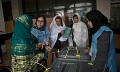 An Afghan election worker explains the voting process to women at a polling station in Kabul, Afghanistan.