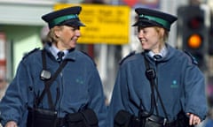 Two traffic wardens patrol smiling on the streets