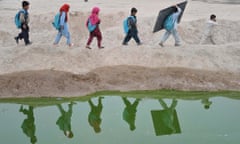 Afghan school children walk  home after classes near an open classroom in the outskirts of Jalalabad on January 30, 2013. Afghanistan has had only rare moments of peace over the past 30 years, its education system being undermined by the Soviet invasion of 1979, a civil war in the 1990s and five years of Taliban rule.