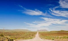 Long gravel road leading to rocky hills on the horizon