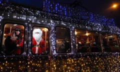 A man dressed as Santa Claus and a woman dressed as mythical creature Krampus travel in a tram decorated with Christmas lights in the centre of Budapest.