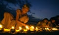 A Sri Lankan woman lights an earthenware lamp as she sits with others at Unawatuna Beach in Galle, some 123 km south of Colombo, 26 January 2005. Sri Lankans lit some 40,000 lamps in memories of those killed by tsunami waves which struck 26 December 2004