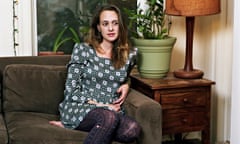 Emiily Gould on a suede sofa next to a plant at home