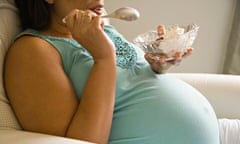 A pregnant woman eating ice cream