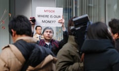 Kolin Burges, a self-styled cryptocurrency trader and former software engineer from London, holds up a placard to protest against Mt. Gox outside the company's Tokyo headquarters.