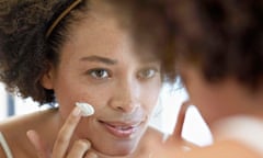 Woman moisturizing her face