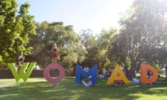 Children play on the Womad sign at Womaelaide 2014, held at the Botanic Gardens in the city.
