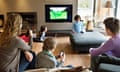 family around a tv with tablets and phones