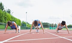 Three women stretching on running track