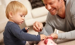 Father and son putting coins in piggy bank