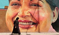 A woman walks past a portrait of Jayalalithaa