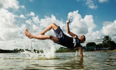 Boy looking to kick a ball in water