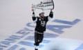 Los Angeles Kings defenseman Alec Martinez carries the Stanley Cup after beating the New York Rangers.