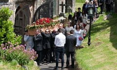 Rik Mayall's coffin is carried into the church in Dittisham, Devon, for his funeral