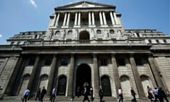 Pedestrians walk past the Bank of England in the City of London