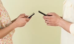 Young couple sending text messages simultaneously