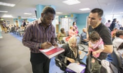 Kenny Wanogho (left) takes down the details of those affected by the housing crisis in Enfield and who have turned to John Wilkes House for help.