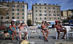 People on beach of Voltri watch Costa Concordia being towed into port