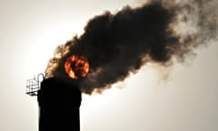 sun seen behind smoke billowing from a chimney of a heating plant in Taiyuan