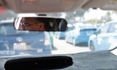 Cab driver Daniel Afeweki looks out from his Toyota Prius cab as he waits in line for his turn to pick up fares at the San Diego airport.