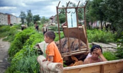 A Roma woman and her child guard their belongings before relocating, after several ramshackle houses were torn down by local authorities in Craica, a shantytown on the outskirts of Baia Mare, Romania