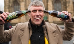 Bez from Happy Mondays messing with his own frack free beer at the unveiling his first election campaign poster on the side of a newsagent's shop in Salford, Greater Manchester