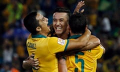 Australia's Jason Davidson (C) celebrates with Tim Cahill and Mark Milligan (R) 