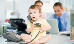 Baby sitting on office desk with telephone