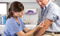 Nurse administers flu jab to older man