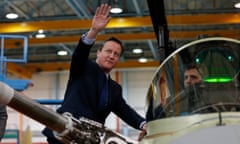 The prime minister, David Cameron, speaking with a worker as he views a military aircraft during his visit to BAE Systems in Preston.
