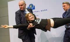 Josephine Witt, a protester who jumped on top of ECB president Mario Draghi's desk during a news conference at the European Central Bank is detained by security.