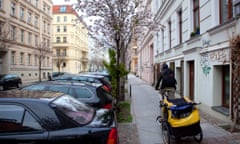 A man cycles along a residential street in Berlin, Germany.