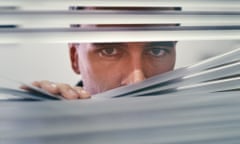 Man peering through blinds