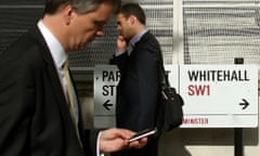 Pedestrians walk past a sign on Whitehall, in Westminster, central London