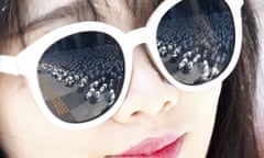 Paper pandas created by French artist Paulo Grangeon are reflected in a woman’s sunglasses during the 1,600 Pandas World Tour which aims to raise awareness of the endangered species.