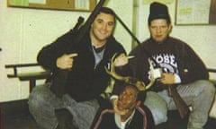 Former Chicago police officers Jerome Finnigan, left, and Timothy McDermott hold rifles over an unidentified man.