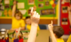 Children raising hands in class