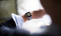 A woman looks at her Apple Watch