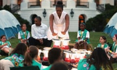 The Obamas with Girl Scouts around a 'fire' made of battery-powered lanterns on the South Lawn of the White House.